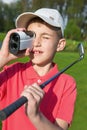 Boy golfer watching into rangefinder