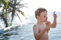 A boy and good ice cream by the pool Royalty Free Stock Photo