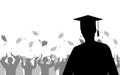 Boy graduate on background of joyful crowd of graduates throwing their academic square caps, silhouettes. Graduation ceremony. Royalty Free Stock Photo