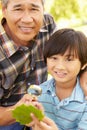 Boy and grandfather examining leaf