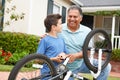 Boy and grandfather fixing bike together