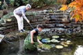 Boy and grandmother cleaning garden pond Royalty Free Stock Photo