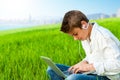 Boy in grass field with city background. Royalty Free Stock Photo