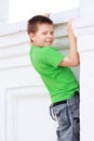 Boy in green climbing on wall Royalty Free Stock Photo