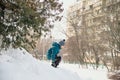 Boy in a green jacket and hat on the hill. Winter city Royalty Free Stock Photo