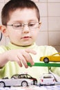 Boy in green playing with cars