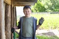 A boy in a green t-shirt, cap, and work gloves. In the backyard in the garden under the roof . The children`s assistant