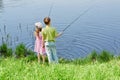 Boy and his sister fish in pond Royalty Free Stock Photo