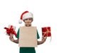 Boy in green t-shirt, santa claus hat with a bag in his teeth and a gift in his hands isolate Royalty Free Stock Photo