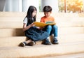 Boy and gril are reading book together,warm light tone