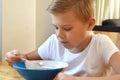 Boy doesn`t want to eat. Unhappy child at the kitchen table. Tasteless food. Royalty Free Stock Photo