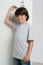 Boy growing tall and measuring himself Royalty Free Stock Photo