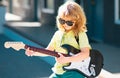 Boy guitarist. Portrait of cute child boy at guitar practice, funny rock child with guitar. Music kids. Royalty Free Stock Photo