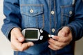 A boy hand holding Glucometer for Blood Glucose Testing on wood table, Healthcare and Medical Glucometer Technology