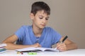 Boy hand holding pen in left hand and writing in a notebook, doing homework. Left Handers Day Royalty Free Stock Photo