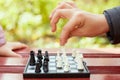 Boy hand holds chess piece above chessboard