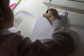 Boy with pencil writing english words by hand on traditional white notepad paper. Royalty Free Stock Photo