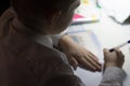 Boy with pencil writing english words by hand on traditional white notepad paper. Royalty Free Stock Photo