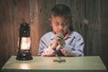 Boy hands praying with a holy cross In the dark and with the lamp beside, Child Praying for God Religion Royalty Free Stock Photo