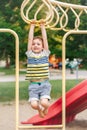 Boy hanging on monkey bars in park on playground. Royalty Free Stock Photo