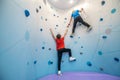 Boy hanging on wall lending helping hand to friend