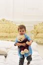 Boy with happy face holds favourite toy fluffy bear. Child with soft teddy bear in hands. Kid play with plush bear