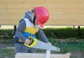 Boy in hard hat with a handsaw sawing a wooden Board Royalty Free Stock Photo