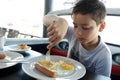 Boy has breakfast in restaurant Royalty Free Stock Photo