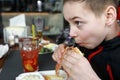 Boy has burger on restaurant terrace Royalty Free Stock Photo