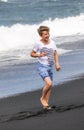 Boy has fun at the black volcanic beach