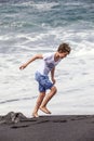 Boy has fun at the black volcanic beach Royalty Free Stock Photo