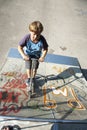 Boy has fun scooting with push scooter at the skatepark Royalty Free Stock Photo