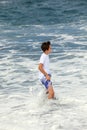 Boy has fun in the spume at the black beach