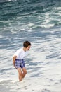 Boy has fun in the spume at the black beach