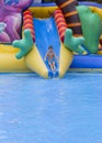 Boy has into pool after going down water slide during summer. little boy sliding down water slide and having Royalty Free Stock Photo