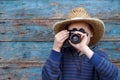 Boy in hat and with a camera at the wooden wall Royalty Free Stock Photo