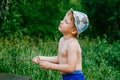 The boy in the hat in the green forest