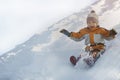 Boy in hat and orange jumpsuit slides off snow slide on back. Portrait. Close-up. Winter day