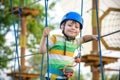Boy having fun at adventure park. toddler climbing in a rope playground structure