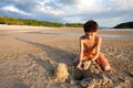 Boy having fun outdoors playing in the sand by the beach at sunset Royalty Free Stock Photo