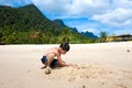 Boy having fun outdoors playing in the sand by the beach in tropical island Royalty Free Stock Photo