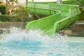 boy is having fun, while spending time in the aquapark. He is sliding down the water slide making a numerous splashes Royalty Free Stock Photo