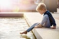 Boy having fun in water fountains. Child playing with a city fountain on hot summer day. Happy kid having fun in fountain. Summer Royalty Free Stock Photo