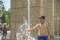 Boy having fun in water fountains. Child playing with a city fountain on hot summer day. Happy kids having fun in fountain. Summer Royalty Free Stock Photo