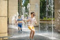 Boy having fun in water fountains. Child playing with a city fountain on hot summer day. Happy kids having fun in fountain. Summer Royalty Free Stock Photo