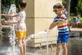 Boy having fun in water fountains. Child playing with a city fountain on hot summer day. Happy kids having fun in fountain. Summer Royalty Free Stock Photo