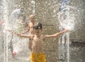 Boy having fun in water fountains. Child playing with a city fountain on hot summer day. Happy kids having fun in fountain. Summer Royalty Free Stock Photo