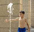 Boy having fun in water fountains. Child playing with a city fountain on hot summer day. Happy kids having fun in fountain. Summer Royalty Free Stock Photo