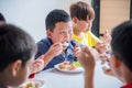 Boy having lunch with friends at school canteen