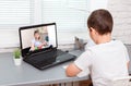 Boy is having a video lesson conference laptop with a teacher at home Royalty Free Stock Photo